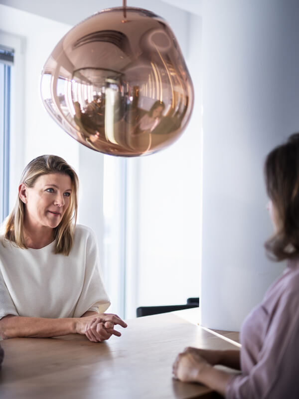 Two women sitting across from each other in an office during an interview