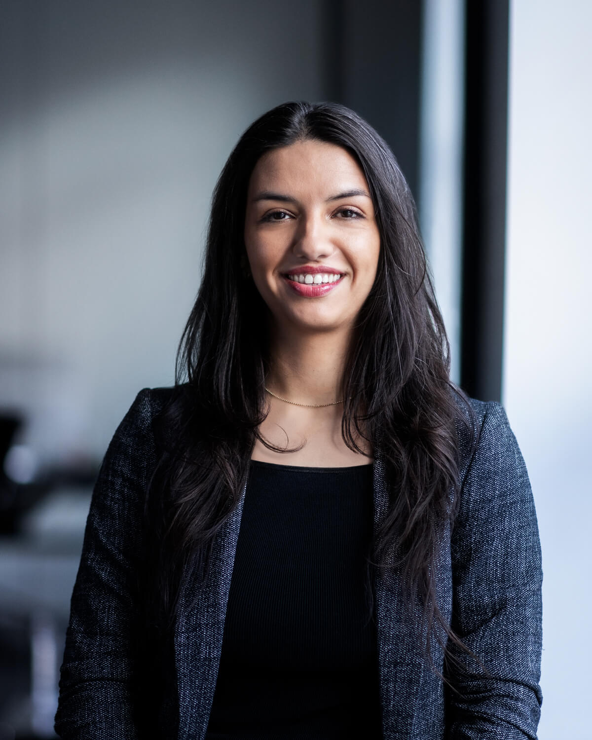 A young female team member in an office and smiling for the camera